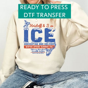 May include: A cream-colored sweatshirt with a distressed blue and red graphic that reads "ICE" with the text "Kristoff & Sven" and "Harvesting and Delivery." The sweatshirt also has the text "Ready to Press DTF Transfer."