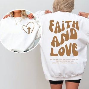a woman wearing a sweatshirt with the words faith and love printed on it