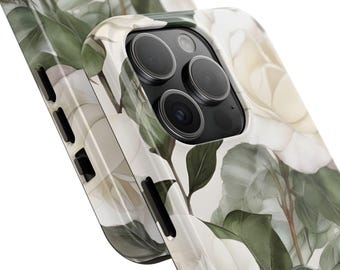 May include: A white and green floral phone case featuring a watercolor design of magnolia flowers and leaves. The case has a glossy finish and a close-up view of the phone's camera and side buttons.