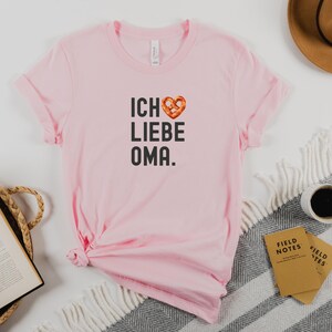 May include: Pink t-shirt with a pretzel heart and the text "ICH LIEBE OMA."