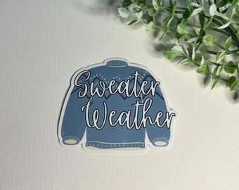 May include: A blue and white sticker with a cartoon sweater and the text "Sweater Weather".