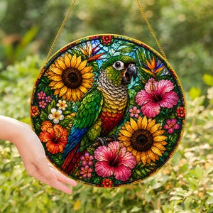 May include: A round, stained-glass window featuring a colorful parrot surrounded by sunflowers, hibiscus, and other flowers. The parrot has green, yellow, red, and blue feathers. The window is framed in gold and hangs from a gold chain.