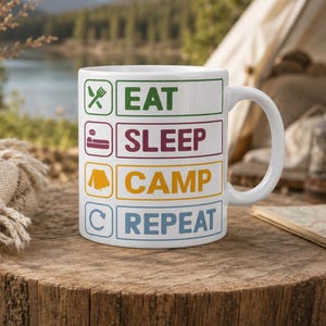 Könnte beinhalten: Ein weißer Keramikbecher mit vier übereinander angeordneten rechteckigen Feldern, die Symbole und Text enthalten. Das grüne Feld zeigt EAT mit Besteck, das weinrote SLEEP mit einem Bett, das gelbe CAMP mit einem Zelt und das blaue REPEAT mit einem Pfeil.