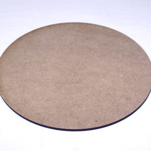 May include: A round, plain, wooden coaster with a light brown colour.