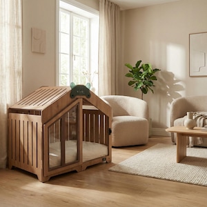 Natural oak indoor dog house placed in a bright, airy living room. This premium wooden crate features modern slat details, glass panels, and a cozy cushion. Perfect for dogs who love sunlight and soft spaces. A stylish pet furniture piece that elevates home décor while providing comfort and safety for small and medium dogs.