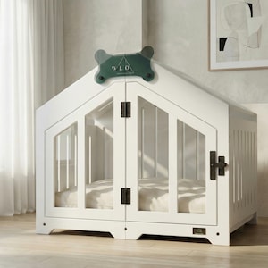 Elegant white dog house with modern lines, shown in a minimal neutral interior. A premium indoor wooden dog crate featuring clear panels, sturdy hardware, and a cozy cushion. Perfect for small to medium dogs needing a calm, stylish retreat. Complements Scandinavian, minimalist, and soft beige home décor effortlessly.