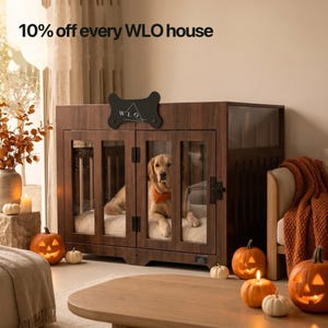 Classic Walnut WLO Pueblo furniture dog crate with a dog inside, styled for Halloween with jack-o-lanterns, candles and autumn leaves, 10% off every WLO dog house