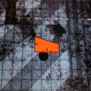 May include: An orange geometric shape with black outlines and numbers 1, 2, and 3, resting on a dark surface. The background features a textured, grid-like pattern in shades of gray and brown.