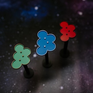 May include: Three colorful, flower-shaped decorative objects on black stems. The objects are green, blue, and red, each with three small, white dots. The background is a dark, starry space.
