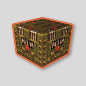 May include: A green and brown cube-shaped block with red lights and a pattern of black and white stripes. The block has the word "MIN" on each side.