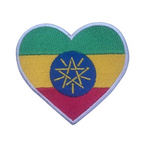 May include: A heart-shaped patch with the Ethiopian flag. The flag is green, yellow, and red with a blue circle in the center containing a gold star and rays.
