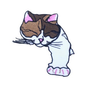 May include: An embroidered iron-on patch of a brown, white, and pink cat with closed eyes, sleeping. The cat is curled up with its paws tucked under its body.