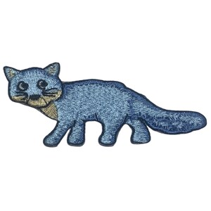May include: Embroidered patch featuring a stylized blue cat with a long tail. The cat has a light tan muzzle and paws, with black eyes and whiskers. The patch is designed to be ironed on or sewn onto fabric.