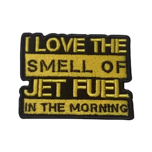 Puede incluir: Parche bordado amarillo con texto negro que dice "Me encanta el olor del combustible de avión por la mañana."