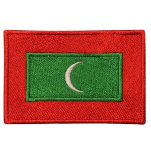 May include: A red rectangular patch with a green rectangle in the center. The green rectangle has a white crescent moon in the center. This is an embroidered patch of the flag of the Maldives.
