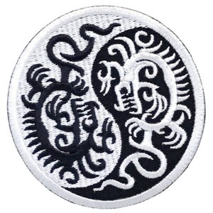 Könnte beinhalten: Schwarz-weiß gestickter Aufnäher mit einem Yin-Yang-Symbol mit einem Drachenmuster auf jeder Seite.