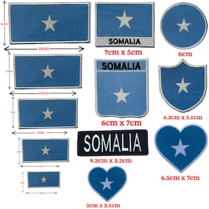 May include: A collection of Somalia flag patches in various shapes and sizes. The patches are primarily blue with a white star in the center. Some patches include the word "SOMALIA". Measurements are in centimeters.