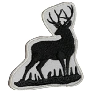 May include: Black embroidered patch of a deer standing in a field of grass. The deer has large antlers and is facing to the right.