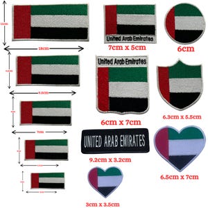 May include: A selection of United Arab Emirates flag patches in different shapes and sizes. Rectangular, circular, and heart-shaped patches display the flag's red, green, white, and black colours. Some patches include the text "United Arab Emirates".