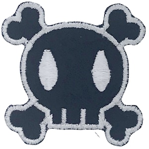 May include: A black and white skull and crossbones patch with a cartoon-like design. The skull has two large white eyes and a white smile.