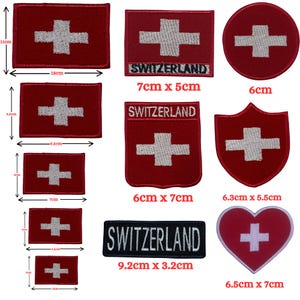 Puede incluir: Un conjunto de diez parches termoadhesivos con la bandera suiza en diferentes formas y tamaños. Los parches son rojos con una cruz blanca y algunos de ellos incluyen la palabra "SWITZERLAND". Los parches varían en tamaño de 6 cm a 9,2 cm.