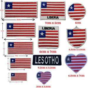 Può includere: Collezione di toppe con bandiera della Liberia e del Lesotho in varie forme e dimensioni. Le toppe della Liberia presentano un quadrato blu con una stella bianca e strisce rosse e bianche. La toppa del Lesotho è rettangolare con testo bianco, 9,2 cm x 3,2 cm.
