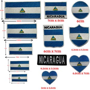 Op de afbeelding: Een verzameling geborduurde patches met de vlag van Nicaragua in verschillende vormen en maten, waaronder rechthoeken, cirkels, schilden en harten. Sommige patches bevatten de tekst NICARAGUA, met afmetingen variërend van 3cm tot 18cm.