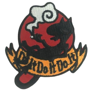 Könnte beinhalten: Gestickter Aufnäher mit einer schwarzen Cartoon-Katze, die raucht, vor rotem Hintergrund mit weißem Rauch. Der Aufnäher enthält ein Banner mit dem Text "Do It Do It" in Orange und Gelb.