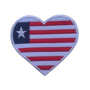 Può includere: Una toppa a forma di cuore rosso, bianco e blu con una stella bianca nel cantone blu. La toppa è ricamata con la bandiera americana.