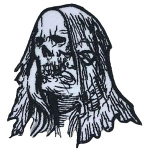 May include: Black and white embroidered patch of a skull with long hair. The skull is detailed with teeth and a tongue sticking out. The hair is long and flowing, with some strands covering the skull's face.