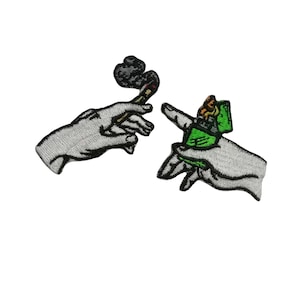 Könnte beinhalten: Zwei gestickte Patches, die Hände zeigen, eine hält eine brennende Zigarette und die andere einen grünen Feuerzeug.