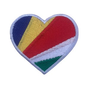 Puede incluir: Un parche en forma de corazón con la bandera de Seychelles. La bandera está compuesta por cinco colores: azul, amarillo, rojo, blanco y verde.