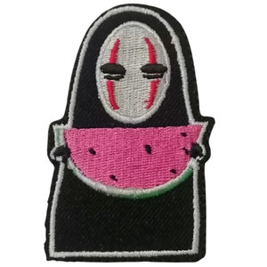 Puede incluir: Parche bordado para planchar con un personaje de dibujos animados con una máscara blanca y ojos rojos que sostiene una rebanada de sandía. El personaje lleva una túnica negra con costuras blancas.