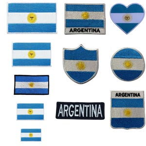 May include: A set of ten embroidered iron-on patches featuring the Argentinian flag in various shapes and sizes. The patches include a heart, a shield, a circle, and rectangular shapes. Some patches include the word "ARGENTINA" in black text.