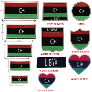 May include: A selection of Libya flag patches in different shapes. The patches display the flag's red, black, and green stripes, a white crescent moon, and a star. Sizes vary from 3 cm to 18 cm in length.