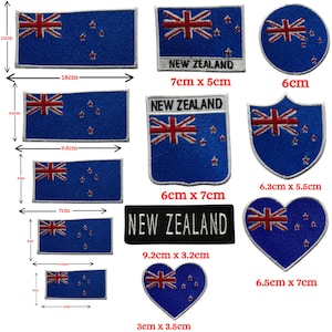 May include: A variety of blue fabric patches displaying the New Zealand flag, with a red and white Union Jack and four red stars. The patches come in different shapes and sizes, including rectangular, circular, and heart-shaped. Some patches have the text "NEW ZEALAND".