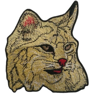 May include: Embroidered patch of a bobcat's face, with a tan and brown fur pattern, black eyes, and a pink nose.