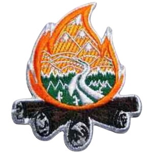 May include: An embroidered patch depicting a campfire with a mountain scene within the flames. The flames are orange and yellow, the mountains are brown and yellow, and the trees are green. The logs are brown and black.