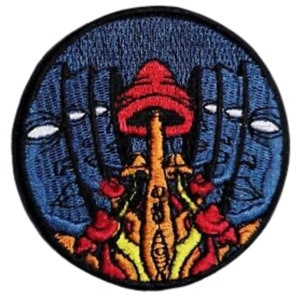 May include: Embroidered patch featuring a red and orange mushroom with a blue background. The mushroom is surrounded by three faces with white eyes. The patch is circular and has a black border.