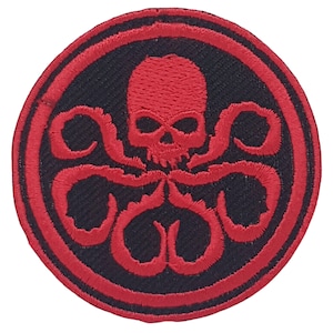 Op de afbeelding: Rode en zwarte geborduurde patch met een schedel en tentakels, vergelijkbaar met het logo van de fictieve organisatie HYDRA.