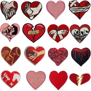 Peut inclure: Une collection d'écussons en forme de cœur avec divers motifs. Certains écussons présentent des mains, des crânes et des cœurs brisés. Les couleurs incluent le rouge, le rose et le blanc. Les écussons sont probablement destinés aux vêtements ou aux accessoires.