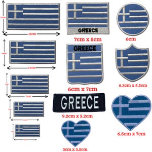 May include: A selection of blue and white Greek flag patches in different shapes. Rectangular, circular, shield, and heart-shaped patches are shown, with measurements in centimetres.