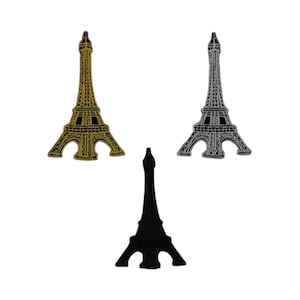Puede incluir: Tres parches termoadhesivos con la Torre Eiffel en dorado, plateado y negro.