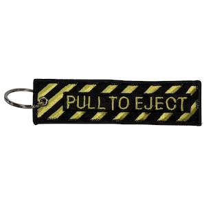 May include: Black and yellow striped key chain with the text "PULL TO EJECT" in yellow.