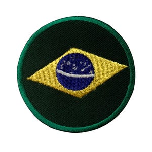 Può includere: Una toppa rotonda ricamata con la bandiera brasiliana. La bandiera è gialla, verde e blu con un cerchio di stelle bianche al centro.