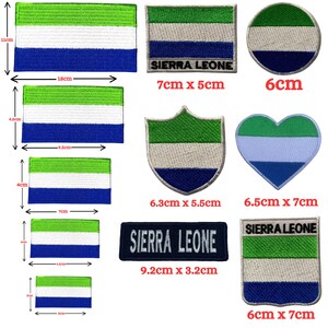 Op de afbeelding: Een collectie geborduurde patches met de vlag van Sierra Leone in groen, wit en blauw. De vormen omvatten rechthoeken, cirkels, harten en schilden. Sommige patches bevatten de tekst SIERRA LEONE. De maten variëren van 3 cm tot 18 cm breed.
