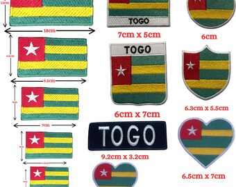Könnte beinhalten: Eine Sammlung bestickter Aufnäher mit der Flagge von Togo in verschiedenen Formen und Größen, darunter rechteckige, runde, schildförmige und herzförmige Designs. Einige Aufnäher enthalten den Text TOGO. Die Maße reichen von 3cm bis 18cm Breite.
