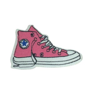 Peut inclure: Patch brodé rose d'une chaussure montante avec une étoile blanche sur le côté.