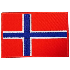 Op de afbeelding: Een geborduurde patch met de vlag van Noorwegen, in de kleuren rood, wit en blauw.
