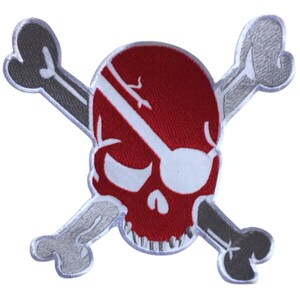 May include: Embroidered patch featuring a red skull with a white stripe and eye patch, crossed with gray bones. The patch has a white border. This patch is suitable for jackets, bags, or other fabric items.